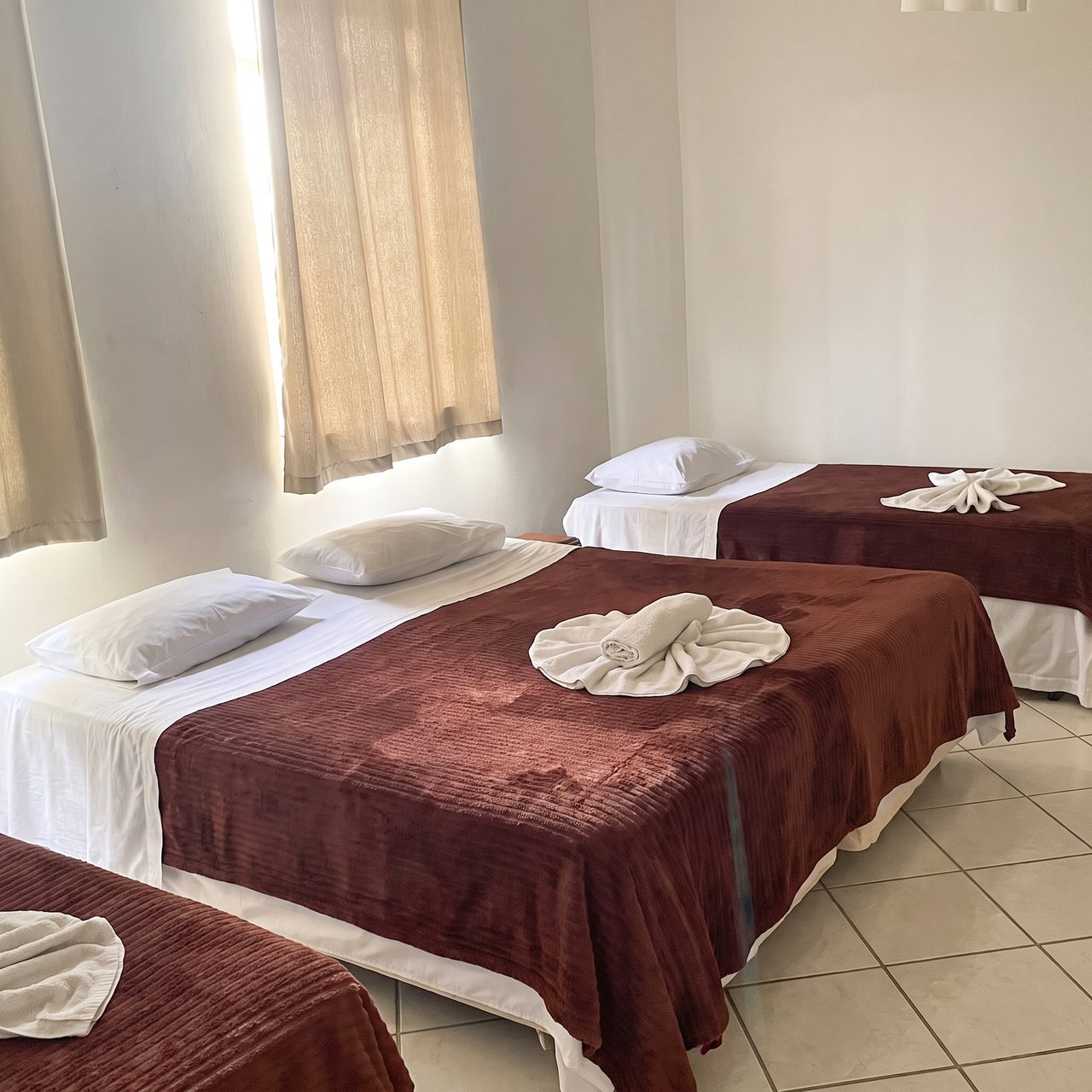 Quarto Quádruplo - Acomodação climatizada com 4 camas de solteiro ou 2 camas de solteiro, 1 cama de casal extragrande e 1 beliche no Hotel Central Campo Grande
